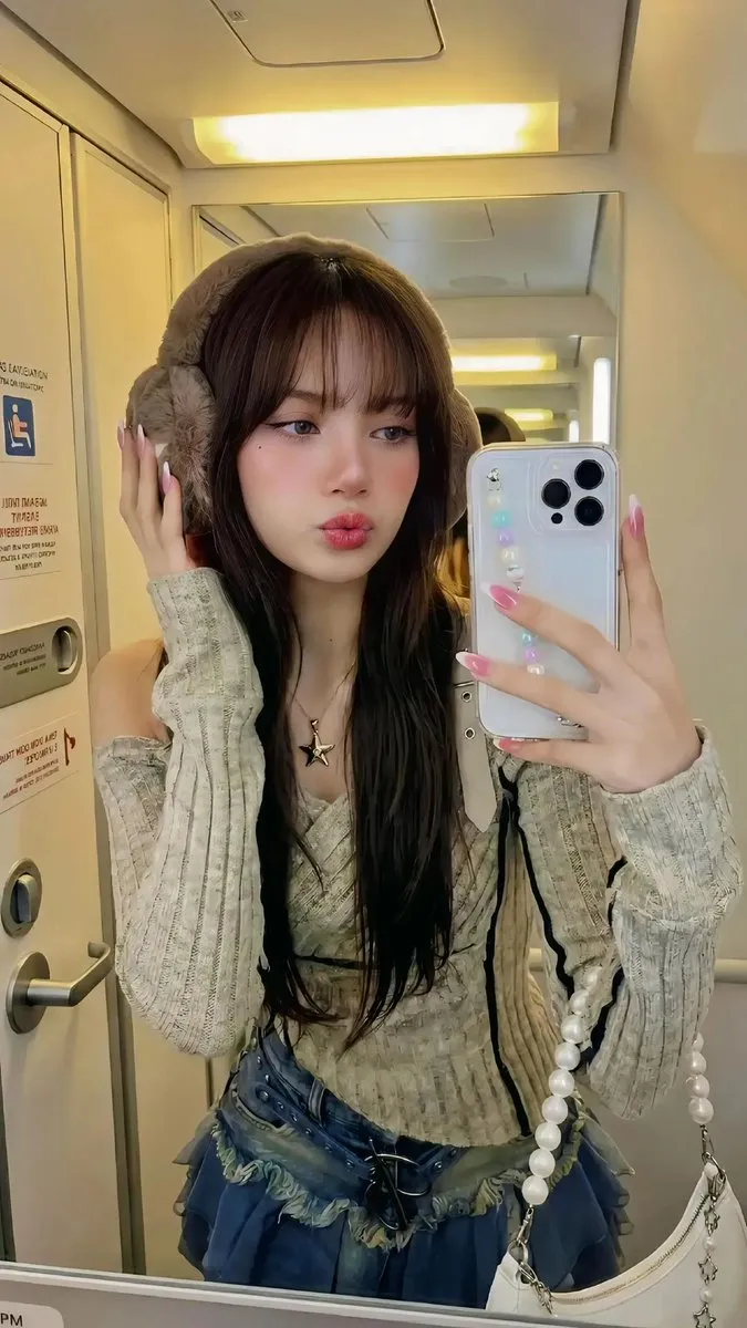 Stylish Young Woman Selfie with Earmuffs on Airplane